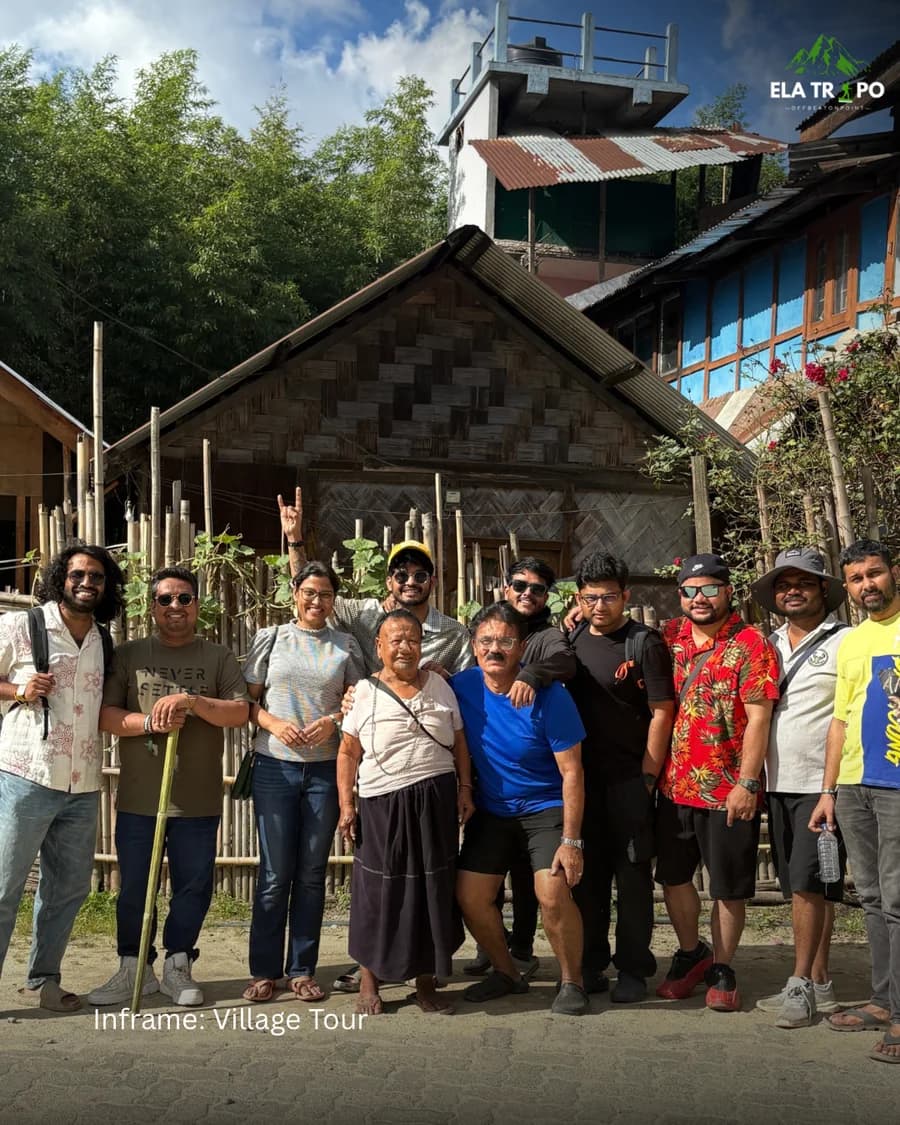 The whole group with a village elder outside a bamboo-walled house in Ziro