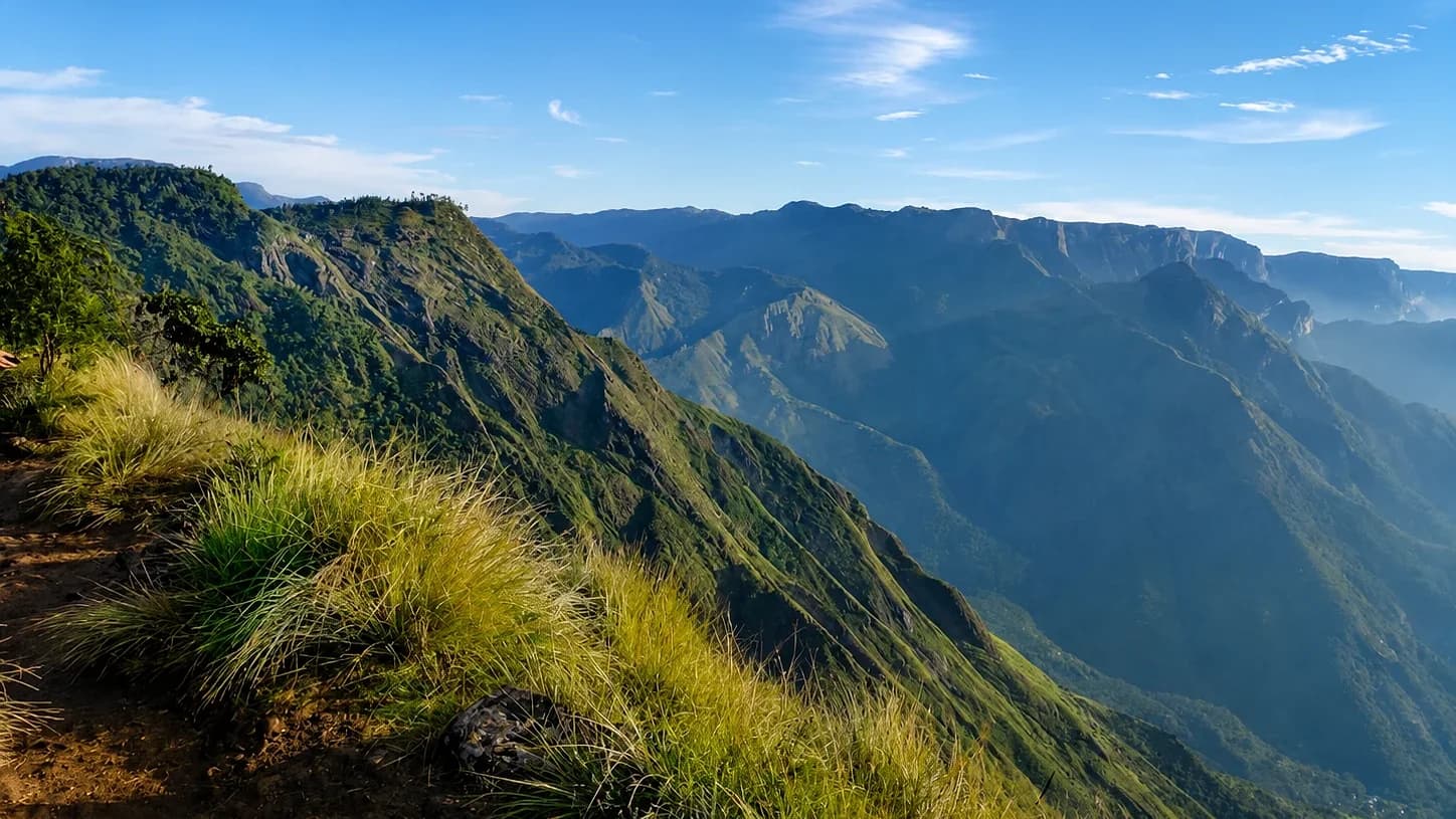 The grass ridge at Laitlum falling away into a deep canyon, ranges receding into haze beyond