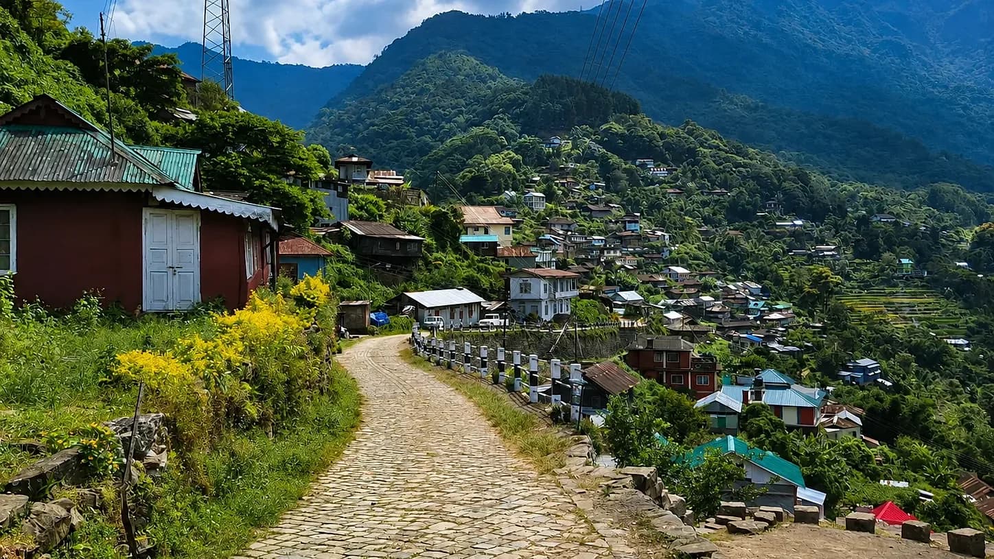 The stone-paved road into Khonoma, tin roofs stepping down the hillside and terraces beyond