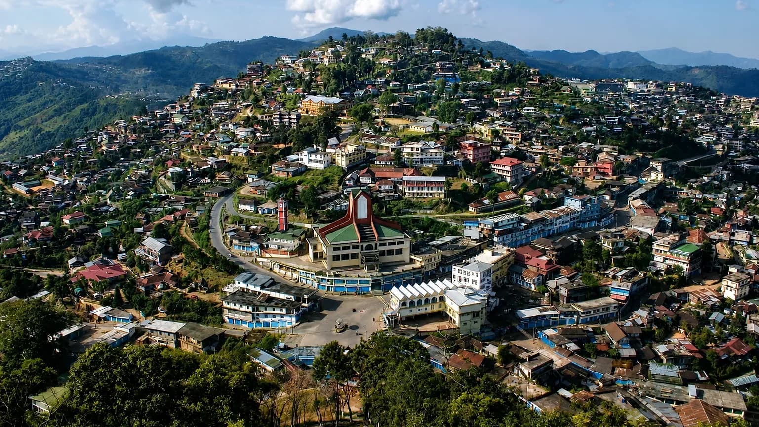 Mokokchung spread along its ridge in afternoon light, the church at the centre of the town